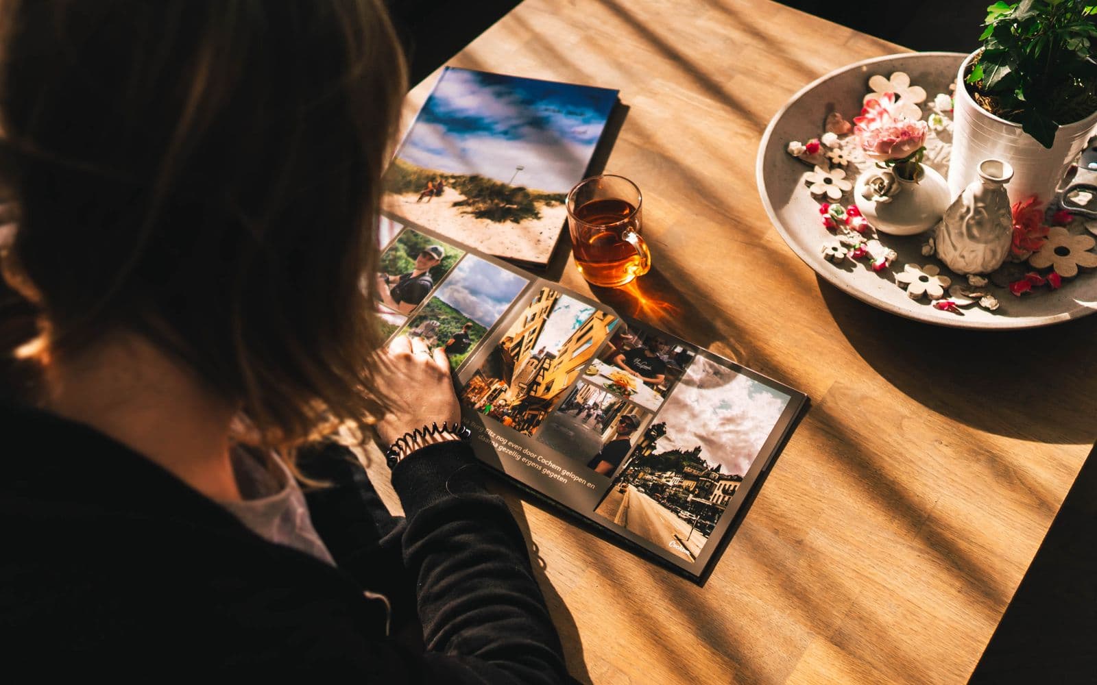 A softcover photo book open on a sunny table